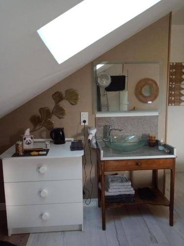 a bathroom with a sink and a dresser with a mirror at La Maison in Mirebeau-sur-Bèze