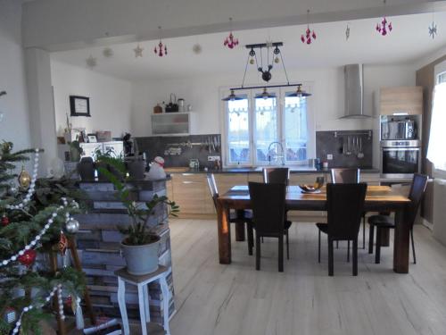a kitchen and dining room with a table and a christmas tree at La Maison in Mirebeau-sur-Bèze