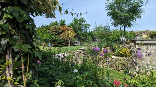 a garden with flowers and a stone wall at La Maison in Mirebeau-sur-Bèze