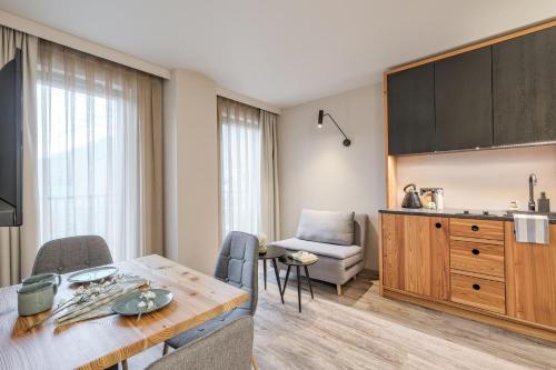 a kitchen and living room with a table and chairs at Harda House Friends & Spa in Zakopane