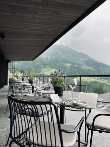 a table with chairs and wine glasses on a balcony at Haven Mountain Retreat in Sankt Johann im Pongau