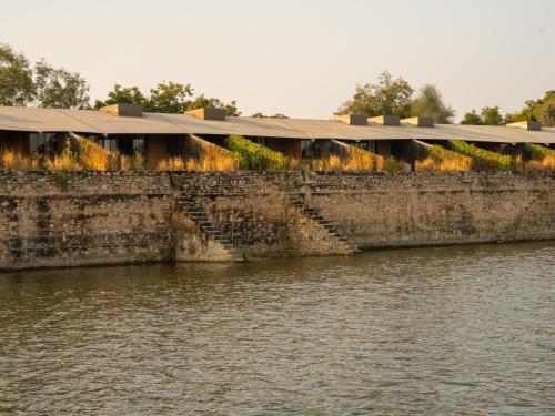 a brick wall next to a body of water at RAAS Chhatrasagar, Nimaj, District Pali in Pāli