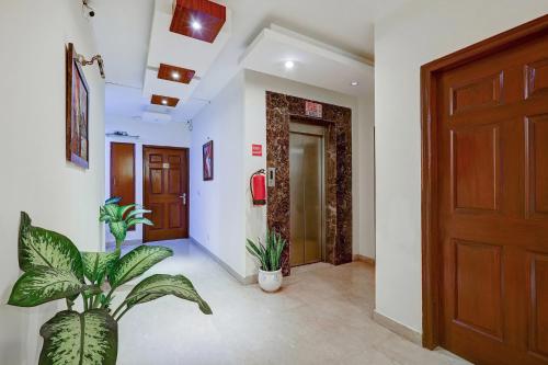 a hallway with a wooden door and plants in it at Hotel B Stays in Gurgaon