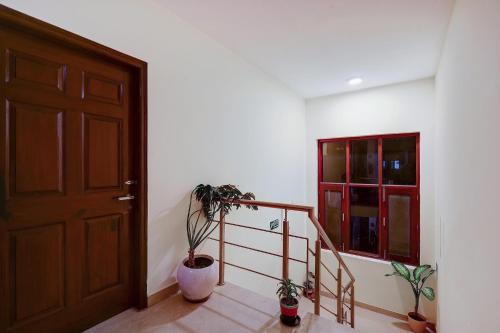a hallway with a door and stairs with plants at Hotel B Stays in Gurgaon