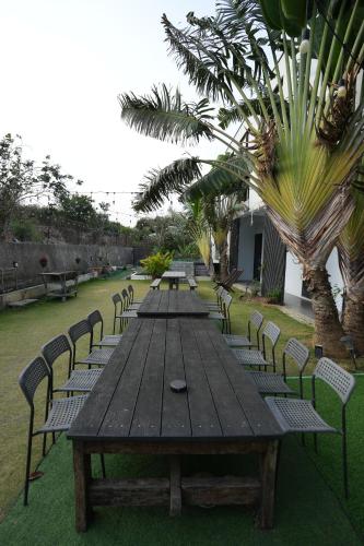 a long wooden table and chairs in a garden at Easyinn in Hengchun