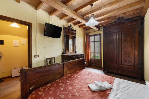a bedroom with a bed and a tv on the wall at Fattoria Delle Vignole in Sommariva Perno