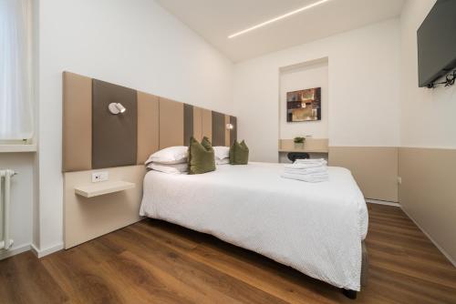 a bedroom with a large white bed and wooden floors at B&B PIEDICASTELLO in Trento