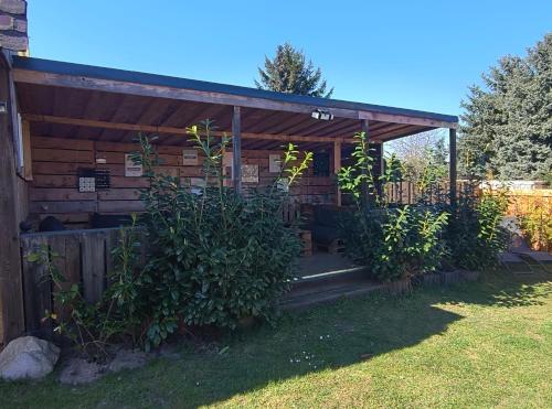 a wooden pergola with a gate and some bushes at Haus Feierabend in Plodda
