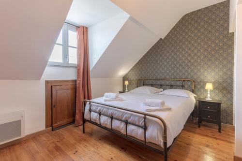 une chambre avec un grand lit dans un grenier dans l'établissement Bourbon Royal, à Pau