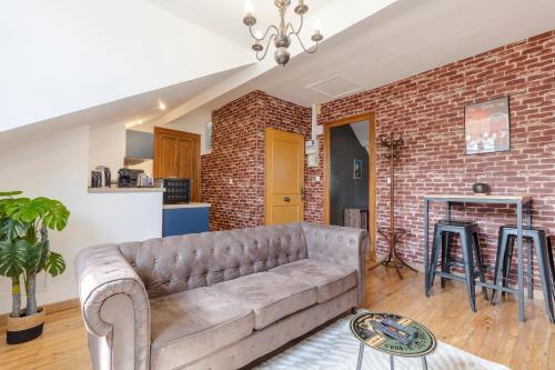 un salon avec un canapé et un mur de briques dans l'établissement Bourbon Royal, à Pau