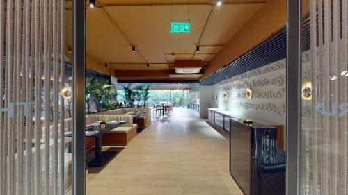 a restaurant with a long corridor with tables and chairs at Priya Hyderabad in Hyderabad