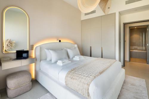 a white bedroom with a bed and a chair at Bella Elite Homes at Grande Signature Full Burj and Fountain View Downtown - Brand New Luxury Apartment in Dubai