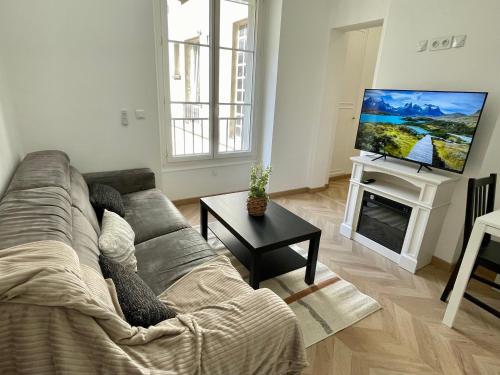 a living room with a couch and a flat screen tv at Appartement Convention Maridor 3 in Paris