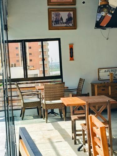 a dining room with tables and chairs and a window at GRAN Parana SUITES HOTEL Asunción Centro in Asuncion