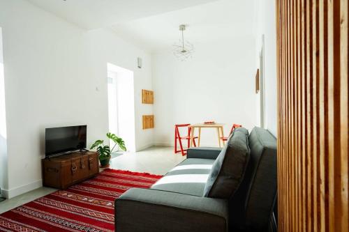 a living room with a couch and a tv at Palmela 33 - in the Heart of Historic Center in Palmela