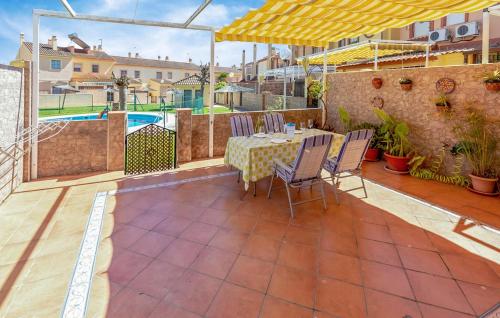 a patio with a table and chairs and a pool at 5 Bedroom Cozy Home In El Portil in El Portil