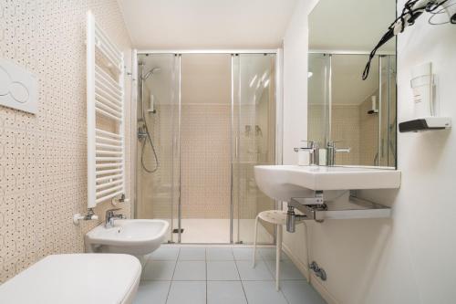 a white bathroom with a sink and a shower at B&B PIEDICASTELLO in Trento