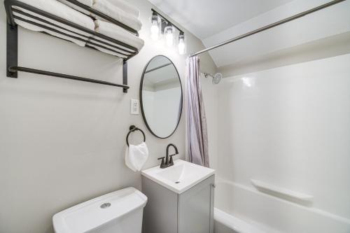 a white bathroom with a sink and a mirror at 2 Mi to Lake Erie Home with Yard in Euclid! in Euclid