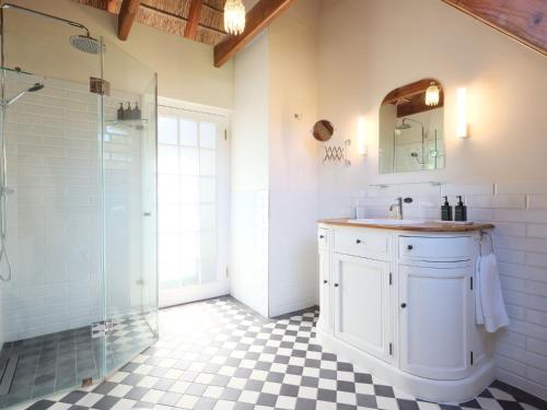 a bathroom with a sink and a glass shower at Adara Palmiet Valley Luxurious Boutique Farm Hotel in Paarl