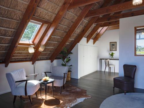 a living room with wooden ceilings and a table and chairs at Adara Palmiet Valley Luxurious Boutique Farm Hotel in Paarl