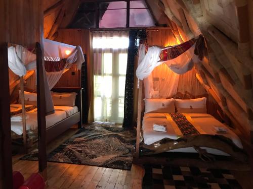 a bedroom with two bunk beds and a window at Masaka Cultural Resort in Masaka