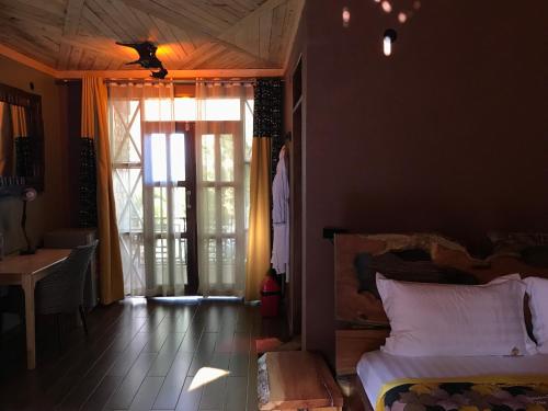 a bedroom with a bed and a table and a window at Masaka Cultural Resort in Masaka