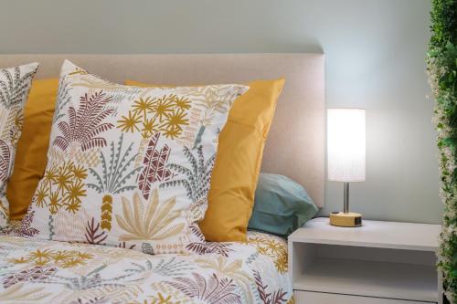 a bed with colorful pillows and a lamp on a table at Nice Renting - GUILLAUMONT - Cozy Studio Beach Picasso Museum Local Market in Antibes
