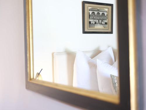 a mirror reflection of a bed with white pillows at Adara Palmiet Valley Luxurious Boutique Farm Hotel in Paarl