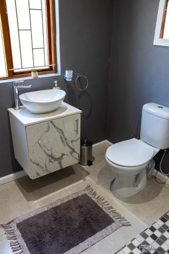 a bathroom with a white sink and a toilet at NamaStay in Cape Town