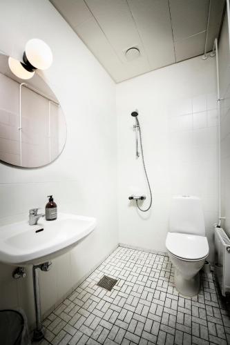 a white bathroom with a toilet and a sink at Jägerhuset på Christianssæde in Maribo