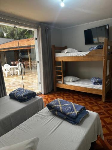 a room with three bunk beds and a patio at Casa Natalino Broleze in Águas de Lindóia