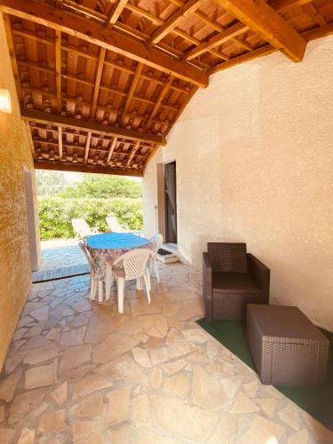 un patio avec une table et des chaises sur un patio dans l'établissement Jolie Villa 6 pers terrasse et Parking 400 m plage - V0736, à Vias