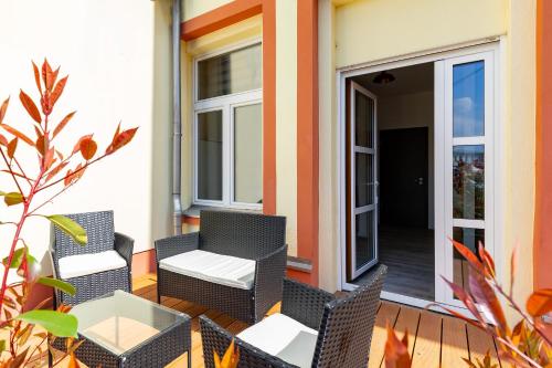 ライプツィヒにあるLoft Apartmentsのパティオ(籐の椅子、ポーチテーブル付)
