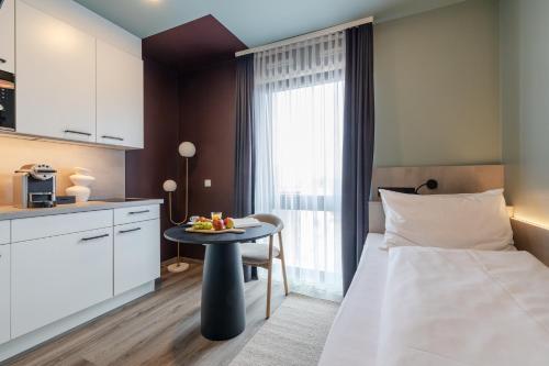 a bedroom with a bed and a table with fruit on it at kalm stay - munich east in Munich