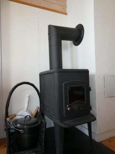 a black stove with a pot and a bucket at Helligvær Kystopplevelser AS in Bodø