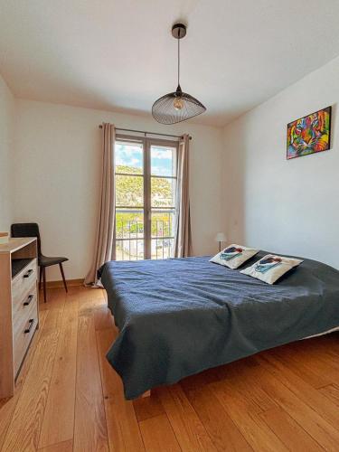 une chambre avec un lit, un bureau et une fenêtre dans l'établissement Magnifique T3 les hauts du port Bonifacio, à Bonifacio