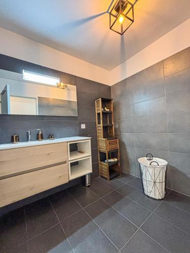 une salle de bain avec un lavabo et un miroir dans l'établissement Magnifique T3 les hauts du port Bonifacio, à Bonifacio