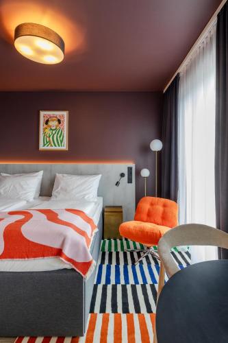 a bedroom with a bed and a chair and a table at kalm stay - munich east in Munich