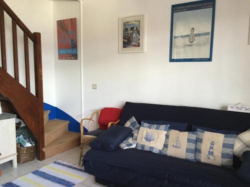 - un salon avec un canapé noir et des oreillers dans l'établissement Charmant duplex centre ville Deauville, à Deauville