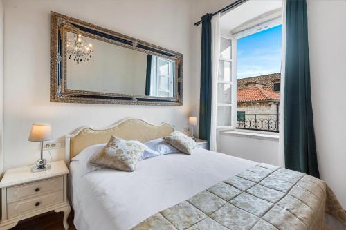 a bedroom with a bed and a large window at Palmotta Palace in Dubrovnik