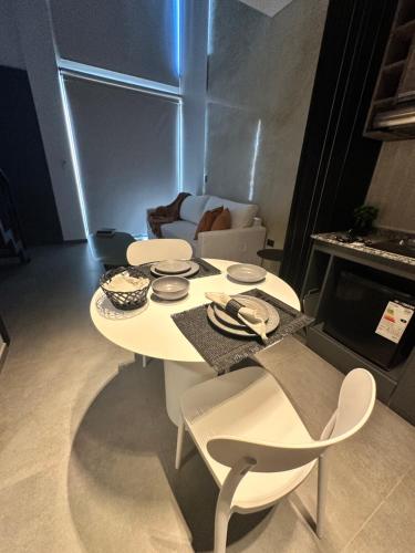 a white table and chairs in a living room at LOFTIER COSTANERA Depto 402 in Posadas
