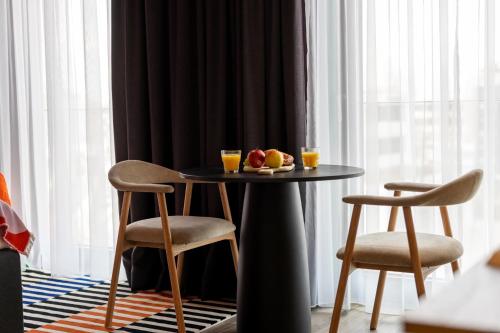 a table with two chairs and two glasses of orange juice at kalm stay - munich east in Munich