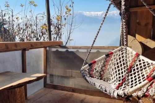 a white hammock hanging on a balcony with a view at ArtVillage Naggar - Entire Katkuni Villa in Nagar