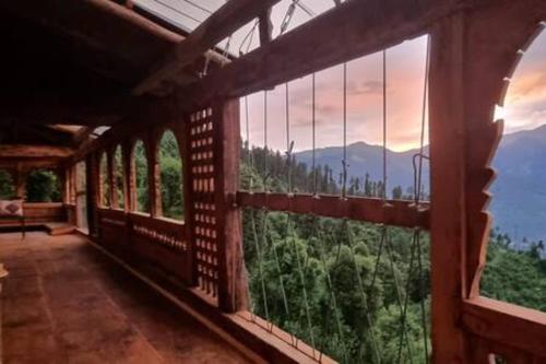 a room with a view of the mountains through windows at ArtVillage Naggar - Entire Katkuni Villa in Nagar