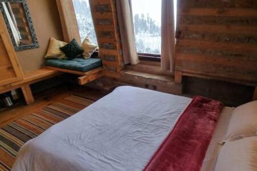 a bedroom with a bed and a window and a couch at ArtVillage Naggar - Entire Katkuni Villa in Nagar