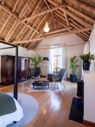a bedroom with a bed and a living room at Adara Palmiet Valley Luxurious Boutique Farm Hotel in Paarl