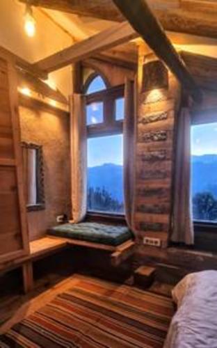 a bedroom with a window with a bed and a rug at ArtVillage Naggar - Entire Katkuni Villa in Nagar
