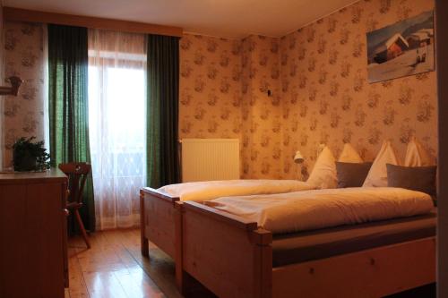 a bedroom with a large bed with a window at Lü de Terza in San Vigilio Di Marebbe