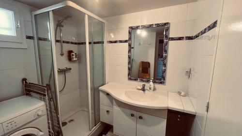 une salle de bain blanche avec un lavabo et une douche dans l'établissement Le Marin des Vertmarines, à Saint-Jean-de-Monts