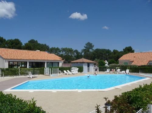 une grande piscine avec des chaises et une personne debout à côté de celle-ci dans l'établissement Le Marin des Vertmarines, à Saint-Jean-de-Monts